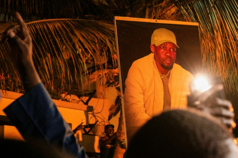 Supporters of Ousmane Sonko holding his portrait during a rally