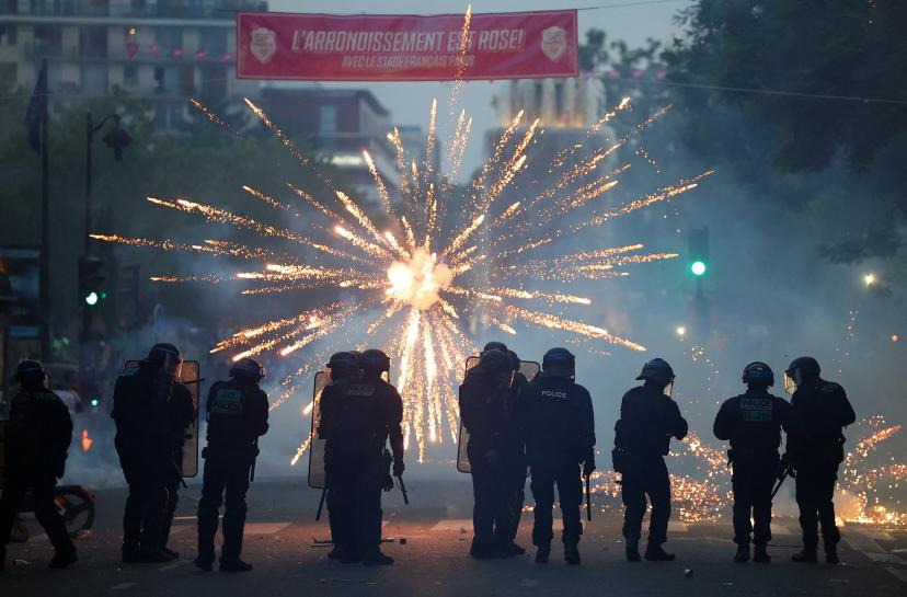 Des feux d'artifice éclatent devant les CRS, samedi soir à Paris. (A. Saboor/Reuters)