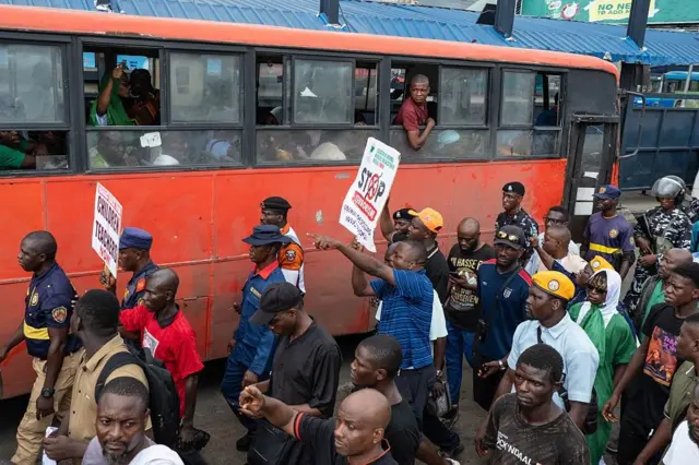 Des manifestants défilent dans les rues d'Ojota, à Lagos, lors des célébrations du 12 juin commémorant le rétablissement de la démocratie en 1999, brandissant des pancartes dénonçant l'enlèvement d'élèves et d'enseignants le 12 juin 2026. 